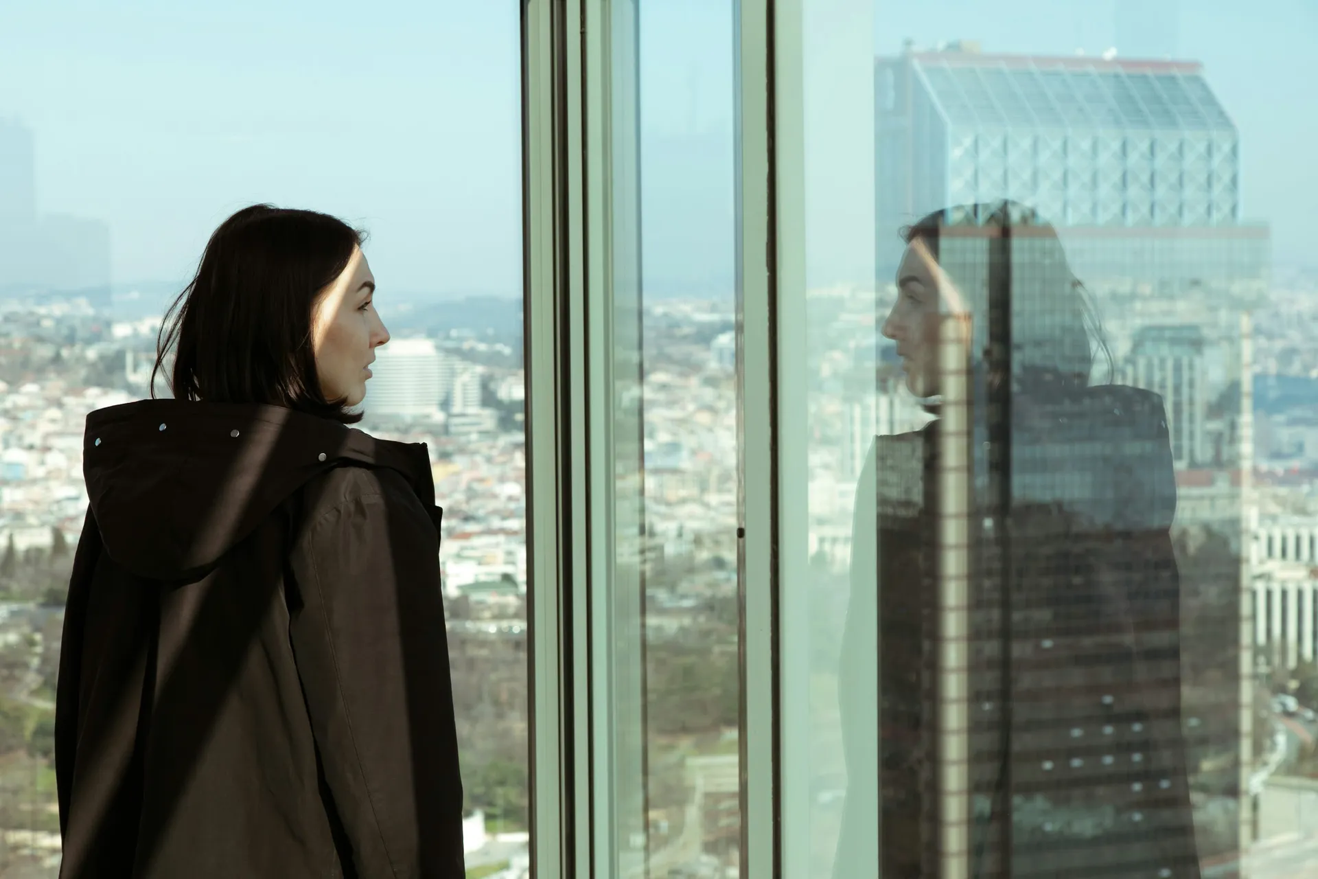 Leadership development expert Atlanta looking through a high-rise window at the city skyline